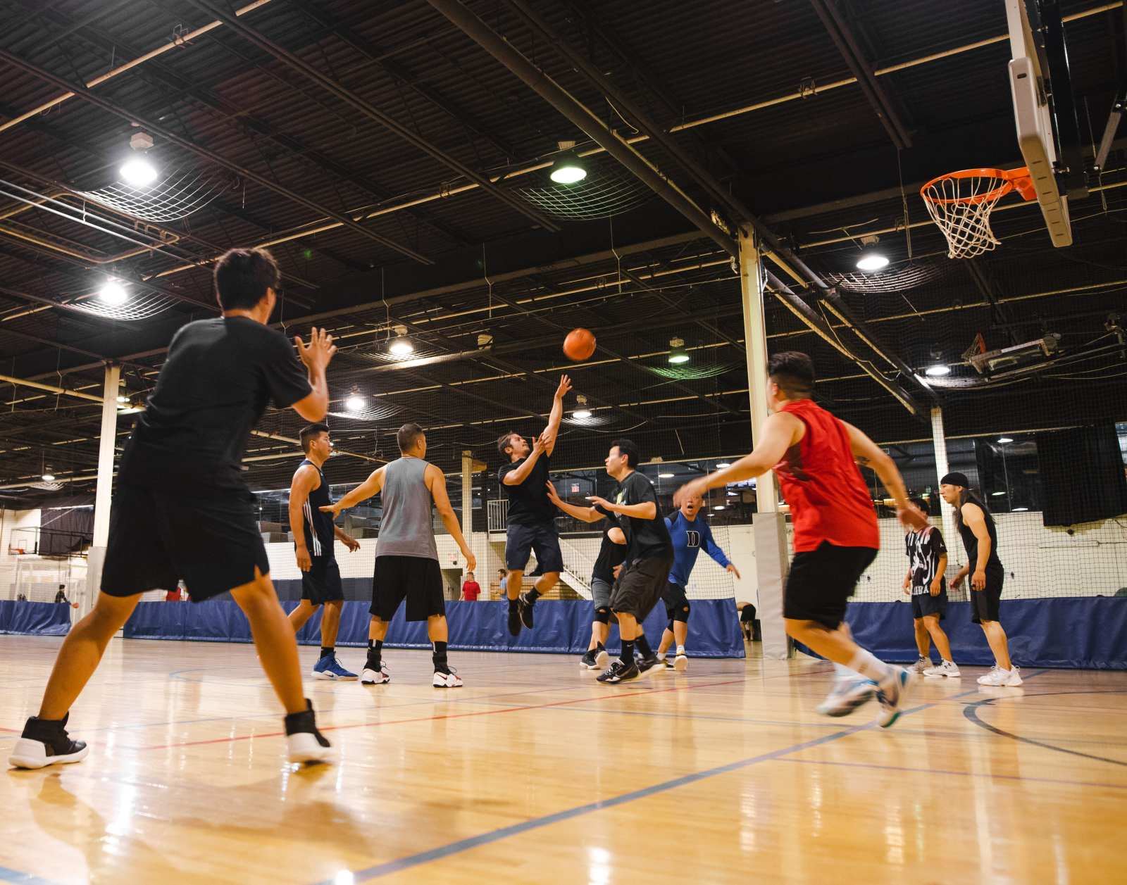 Players mid game on the indoor basketball court at La Liga Sports Complex in North York Toronto