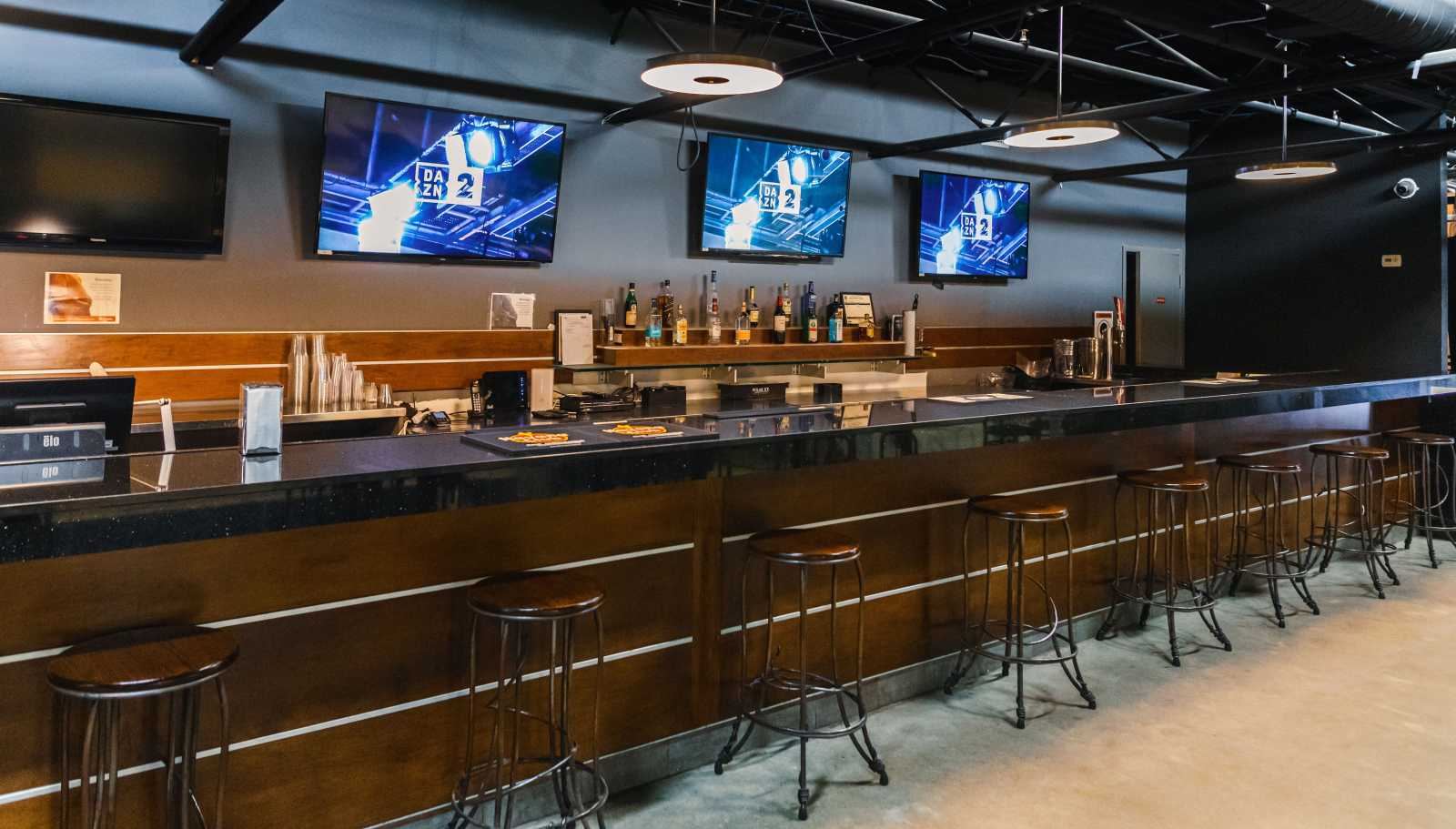 Sports bar screens and seating at La Liga Lounge North York in daylight